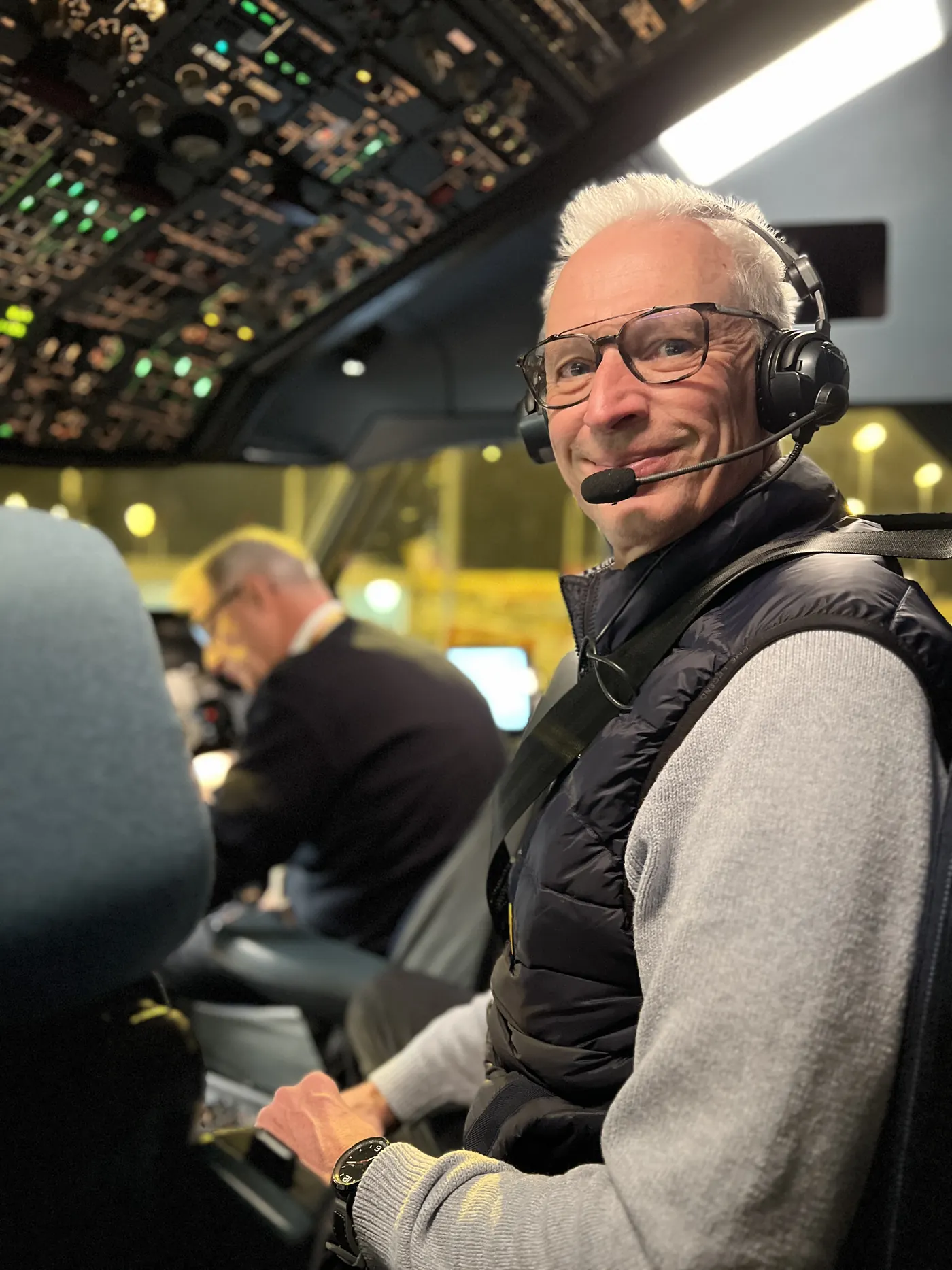 Lutz Schönfeld mit Headset im Cockpit eines Verkehrsflugzeugs